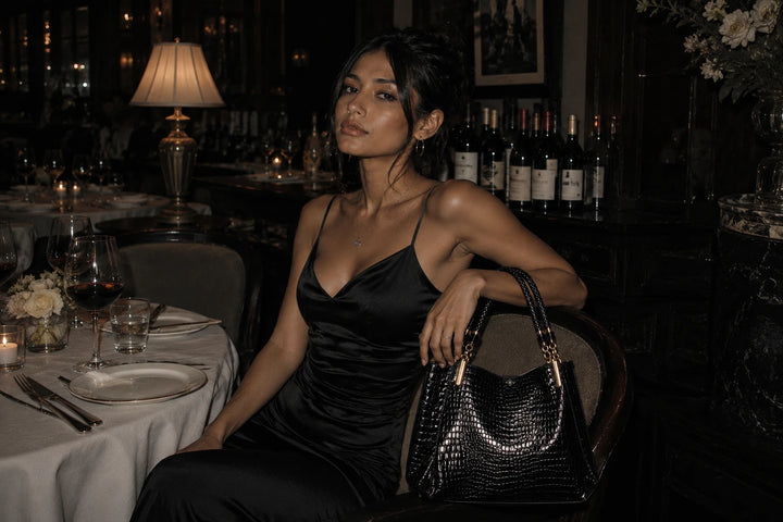 Mulher usando bolsa preta estruturada Femily em ambiente elegante
